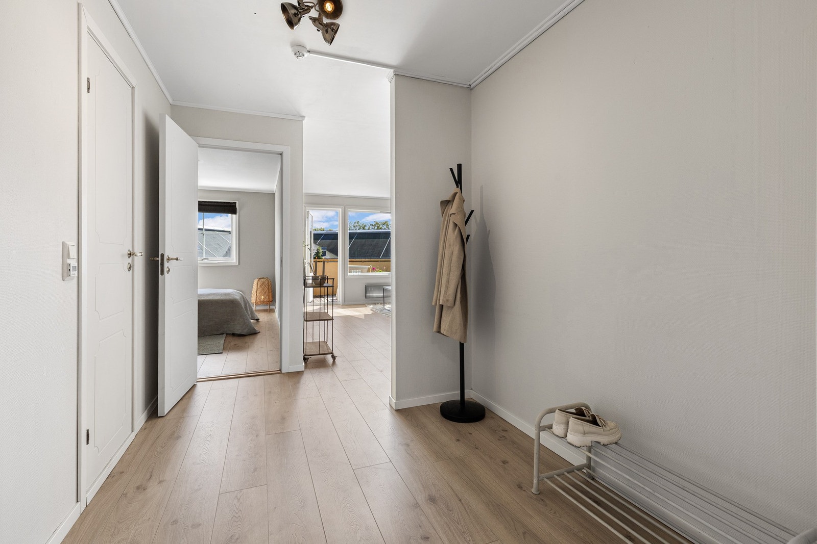 Entréen ønsker deg velkommen med et lyst og moderne preg. Gulvet er belagt med laminat som strekker seg videre inn i leiligheten og skaper en helhetlig stil. Galleribilde