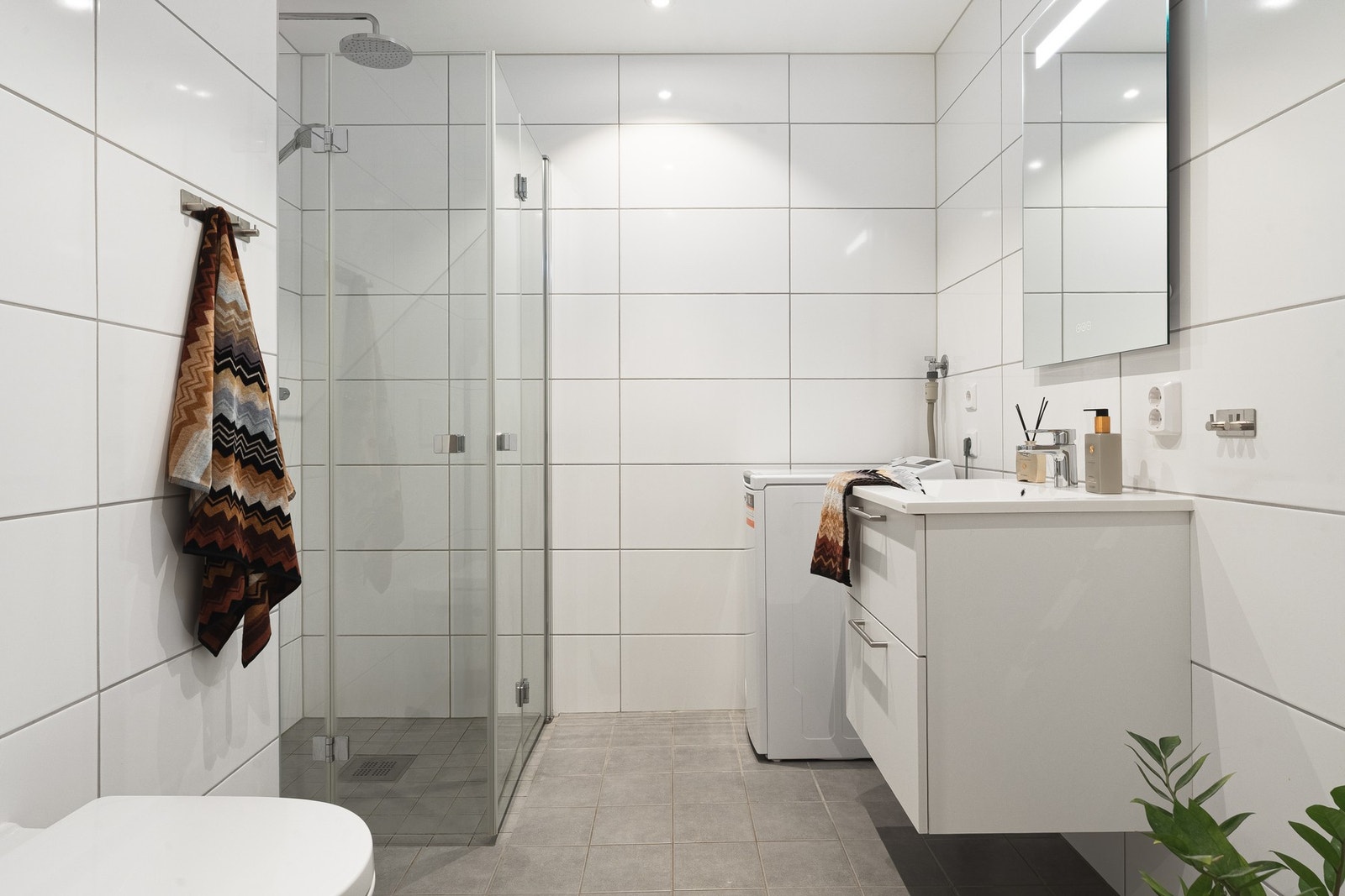 Badet på 4,8 kvm er helfliset med slett, malt himling, innfelte downlights og varmekabler i gulv. Galleribilde