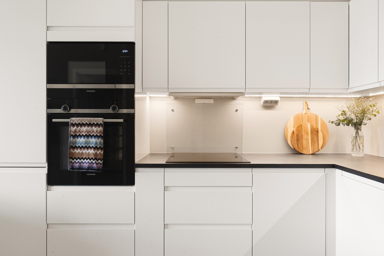 Moderne kjøkken med integrerte hvitevarer: stekeovn, micro, platetopp, oppvaskmaskin, kjøleskap med frysedel og ventilator. Galleribilde