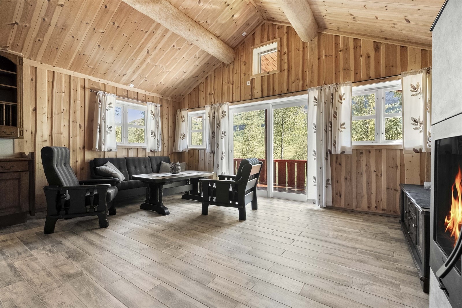 Hytta har ei romslig stove med mønt himling og utgang til terrassen Galleribilde