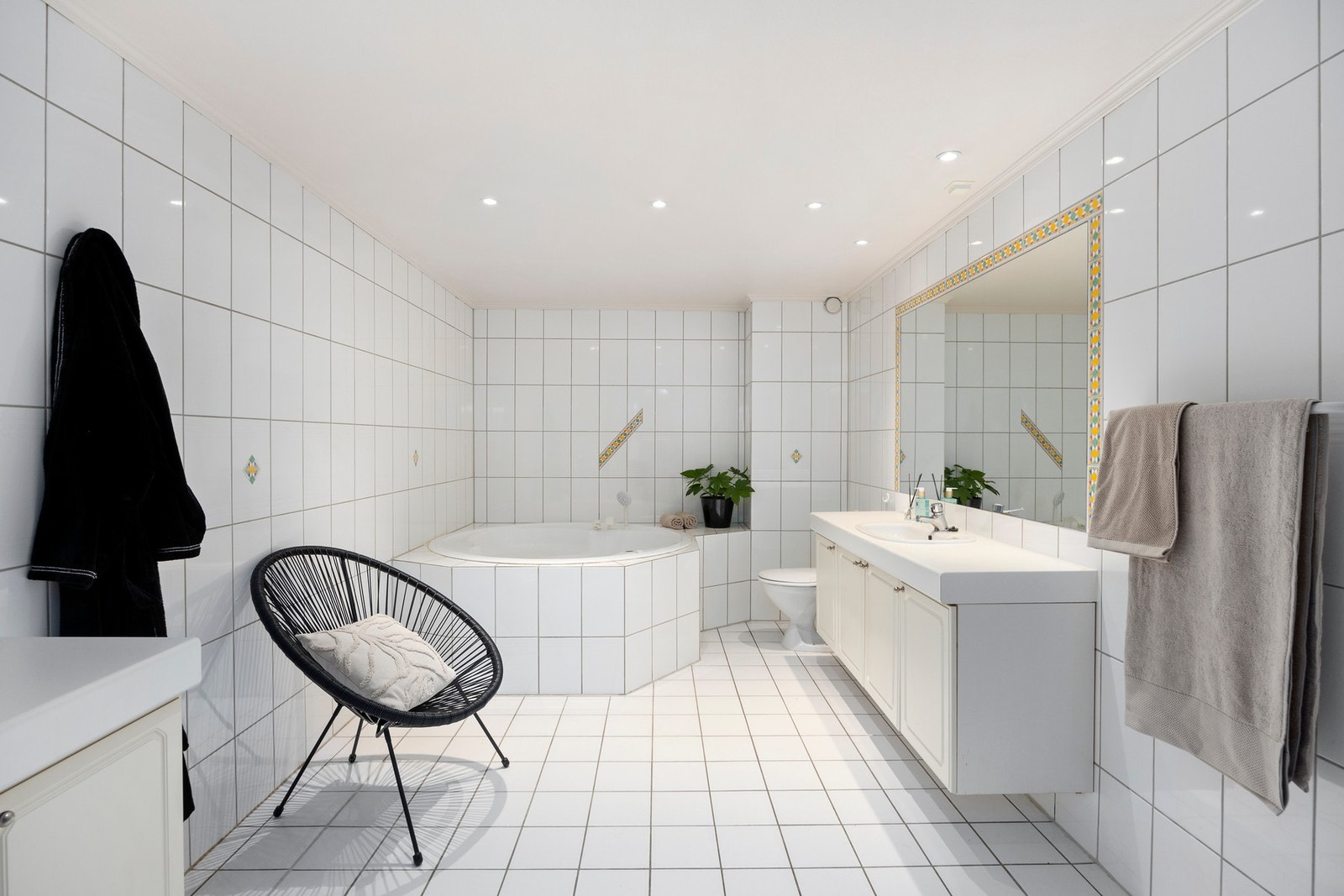 Tilknyttet soverom 1 er et svært romslig bad med flislagte flater, gulvvarme og nedsenket himling med downlights. Galleribilde