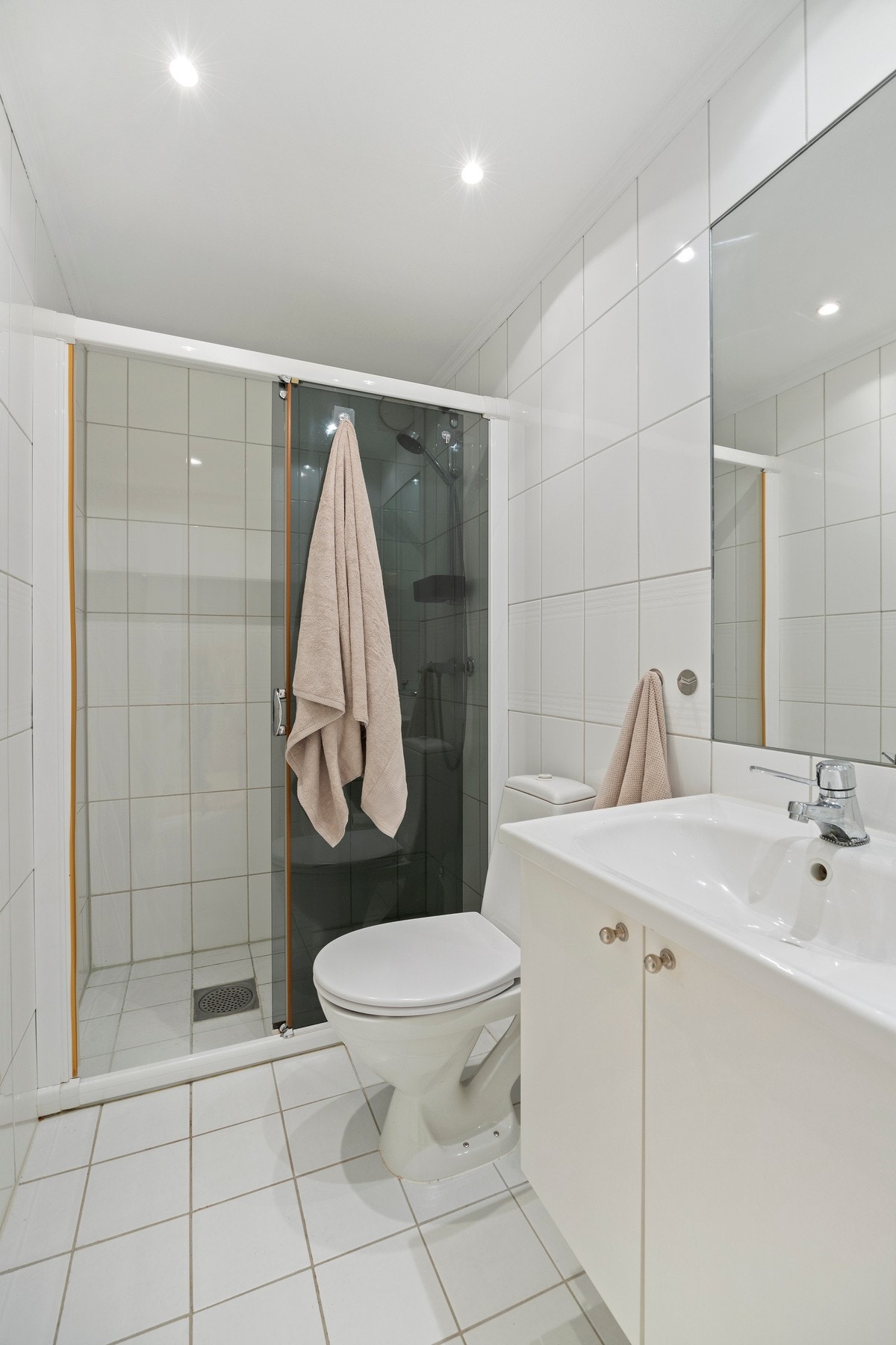 Videre har badet vegghengt servantskap, servant, innfelt speil, stikkontakt og dusjsone med delvegg og skyvedør av glass. Gulvstående toalett. Galleribilde