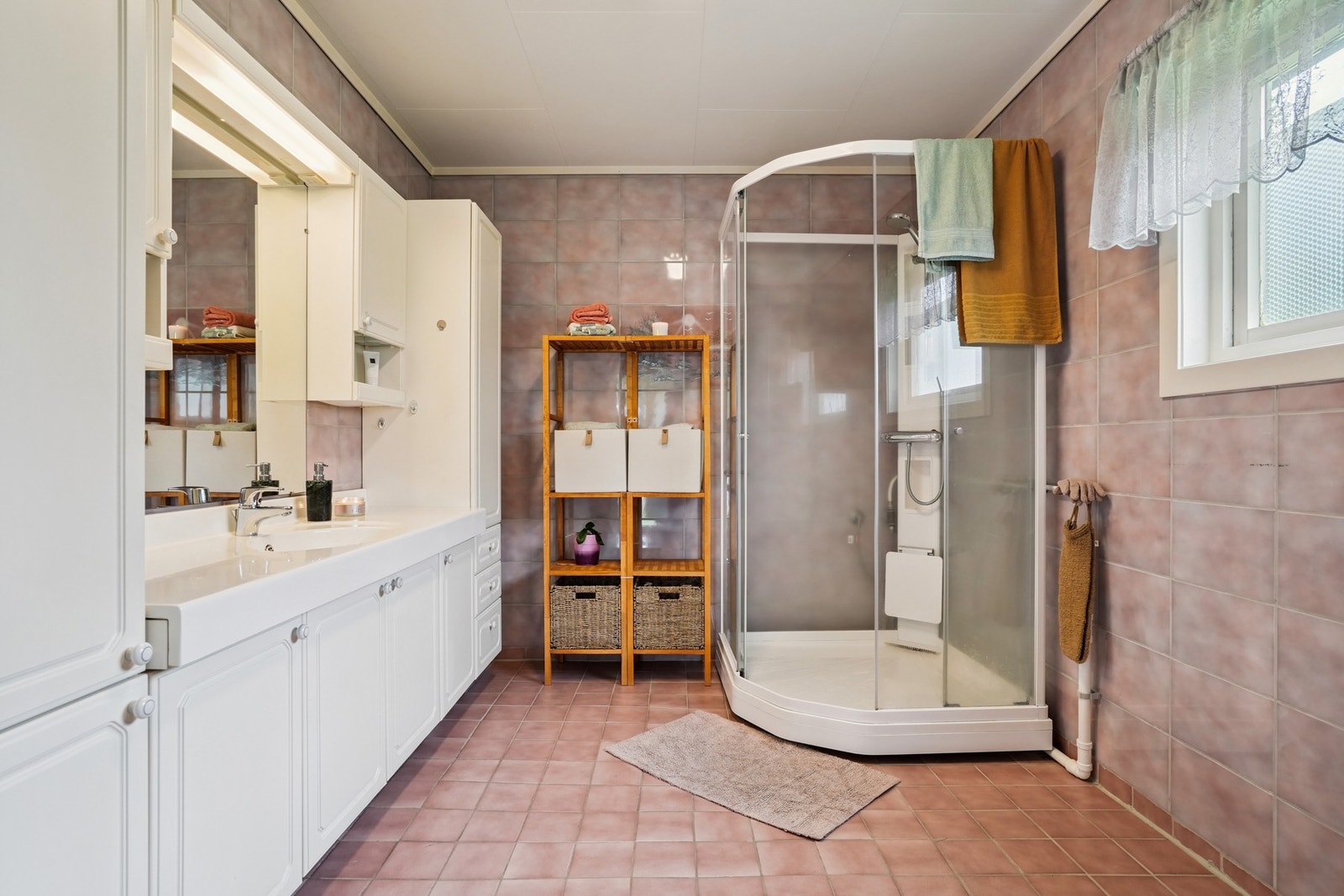 Badet er helfliset, og er romslig av seg. Her er det utstyrt med dusjkabinett, en stor baderomsinnredning og toalett. Galleribilde