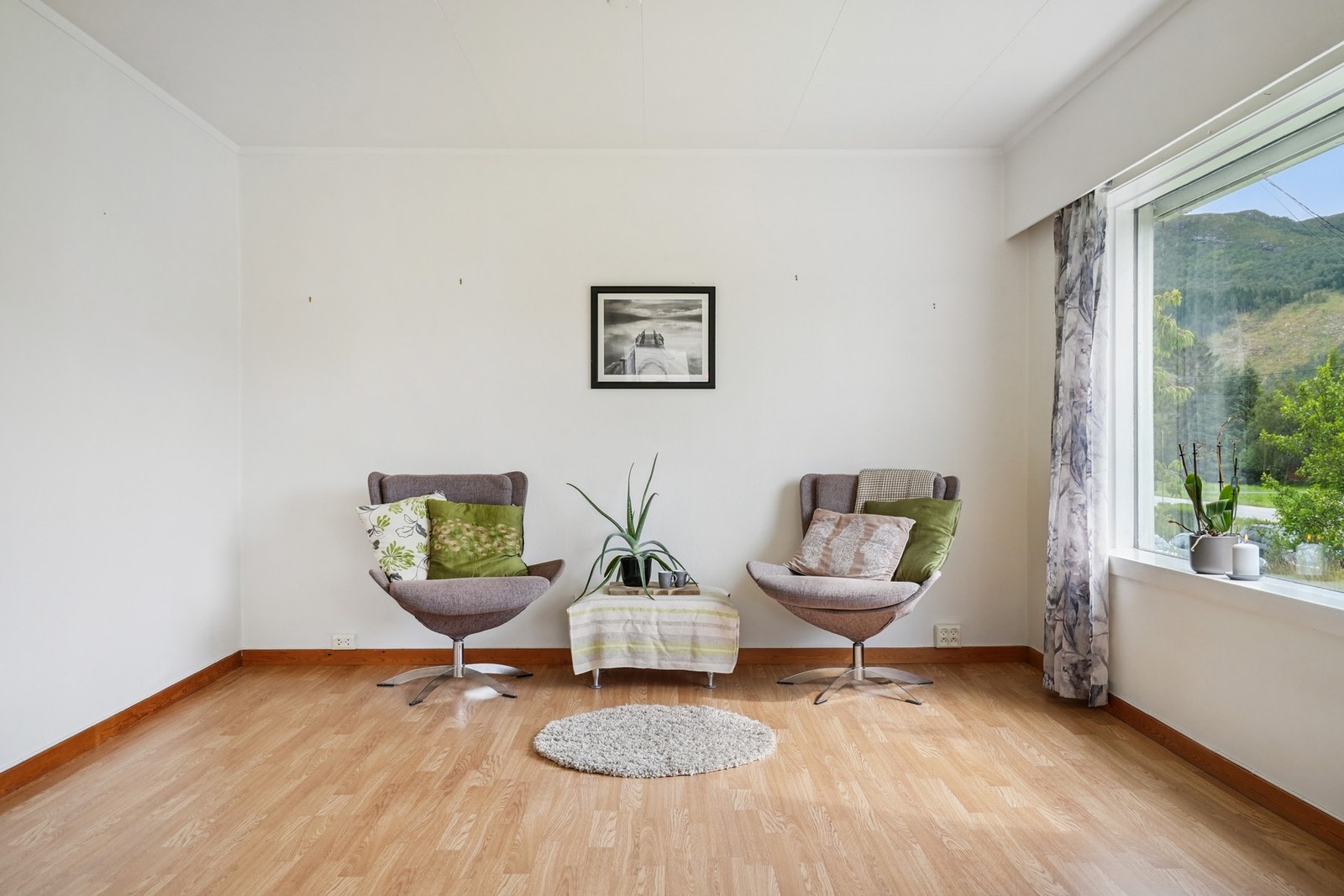 Stuen er romslig av seg og naturlig inndelt i ulike soner - med plass til både spise- og sofagruppe. Galleribilde