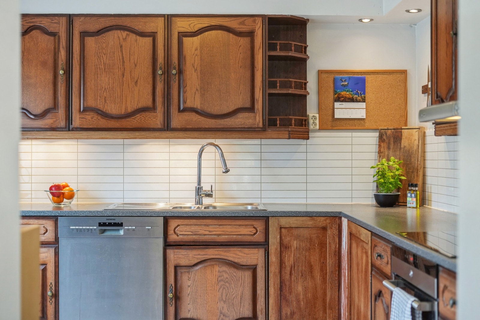 Kjøkkenet har profilerte fronter av heltre og en benkeplate av laminat. Det er belysning under overskapene. Galleribilde