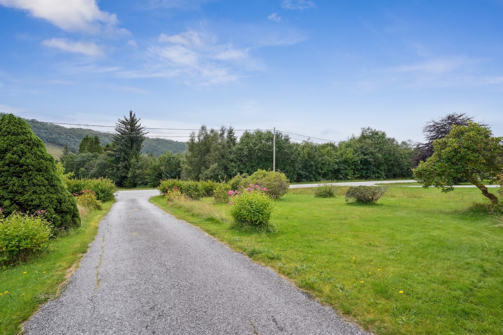 Det er asfaltert innkjørsel til tomten, med svært gode parkeringsmuligheter. Galleribilde