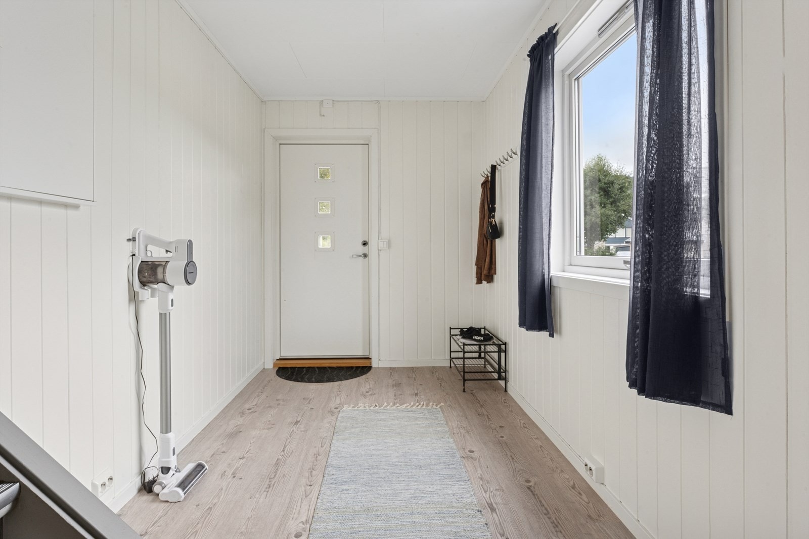 Velkommen inn i en lys og romslig entré med god plass til å henge fra seg yttertøyet Galleribilde