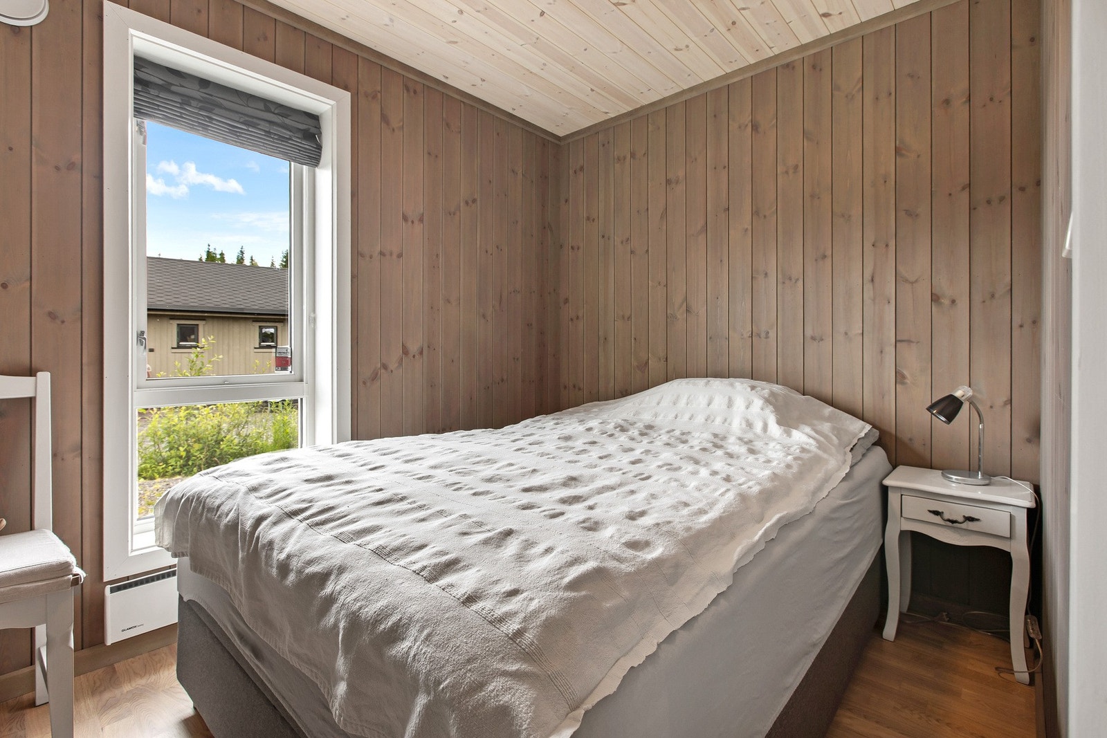 Lyst og lunt soverom med vindu mot tunet. Galleribilde