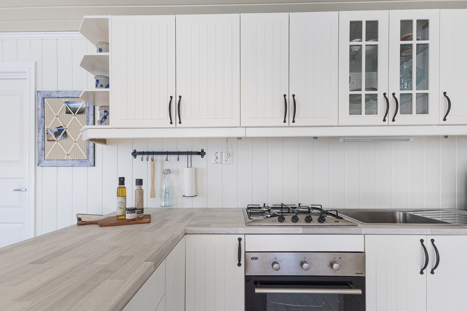 Kjøkken med koketopp, ovn og kjøleskap. Galleribilde