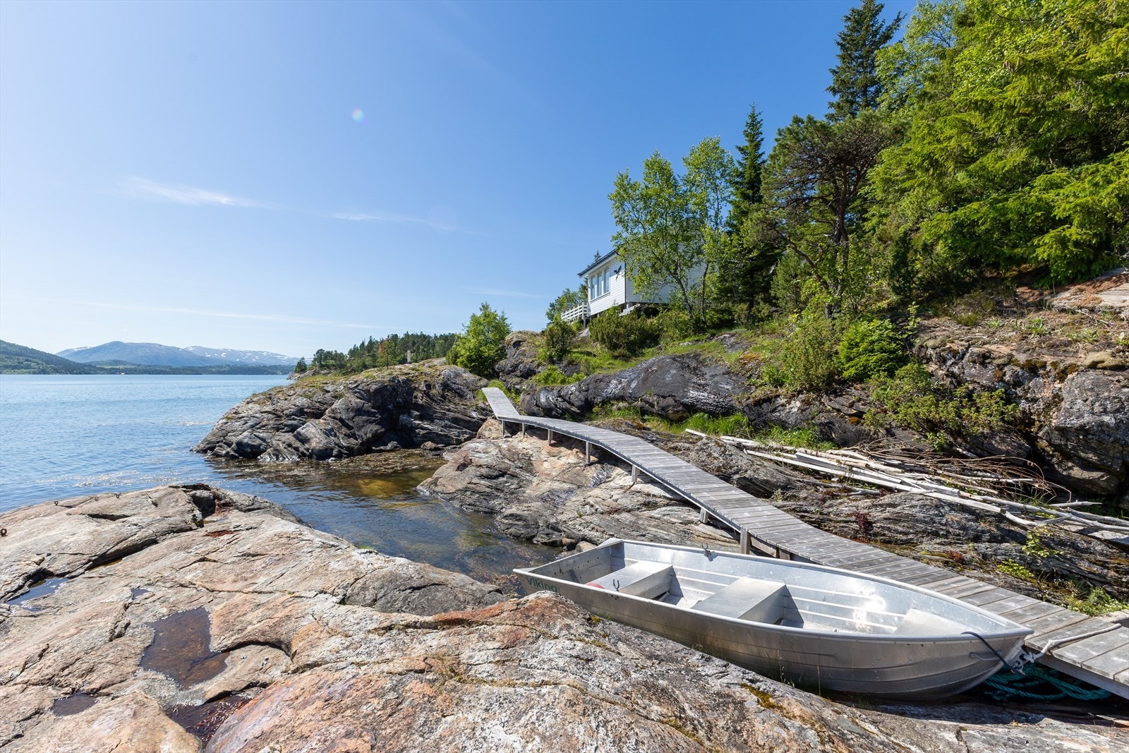 Ved sjøen er det etablert en gangbro mot båtplass. Båt og båtmotor medfølger eiendommen. Galleribilde