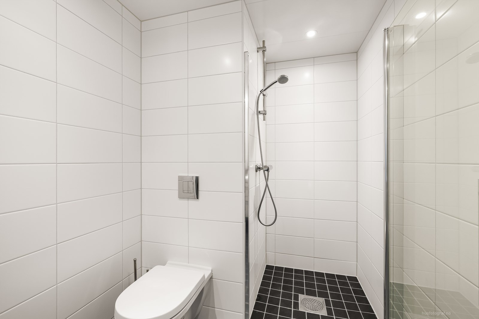 Videre er badet innredet med vegghengt toalett og dusjnisje. Rommet har opplegg for vaskemaskin. Galleribilde