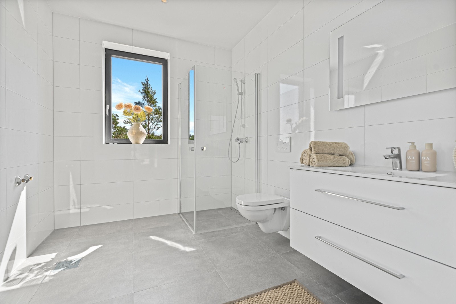 Badet har 60X60 flis og varmekabler i gulv. Vegghengt toalett. Bred servant med lagring. Galleribilde