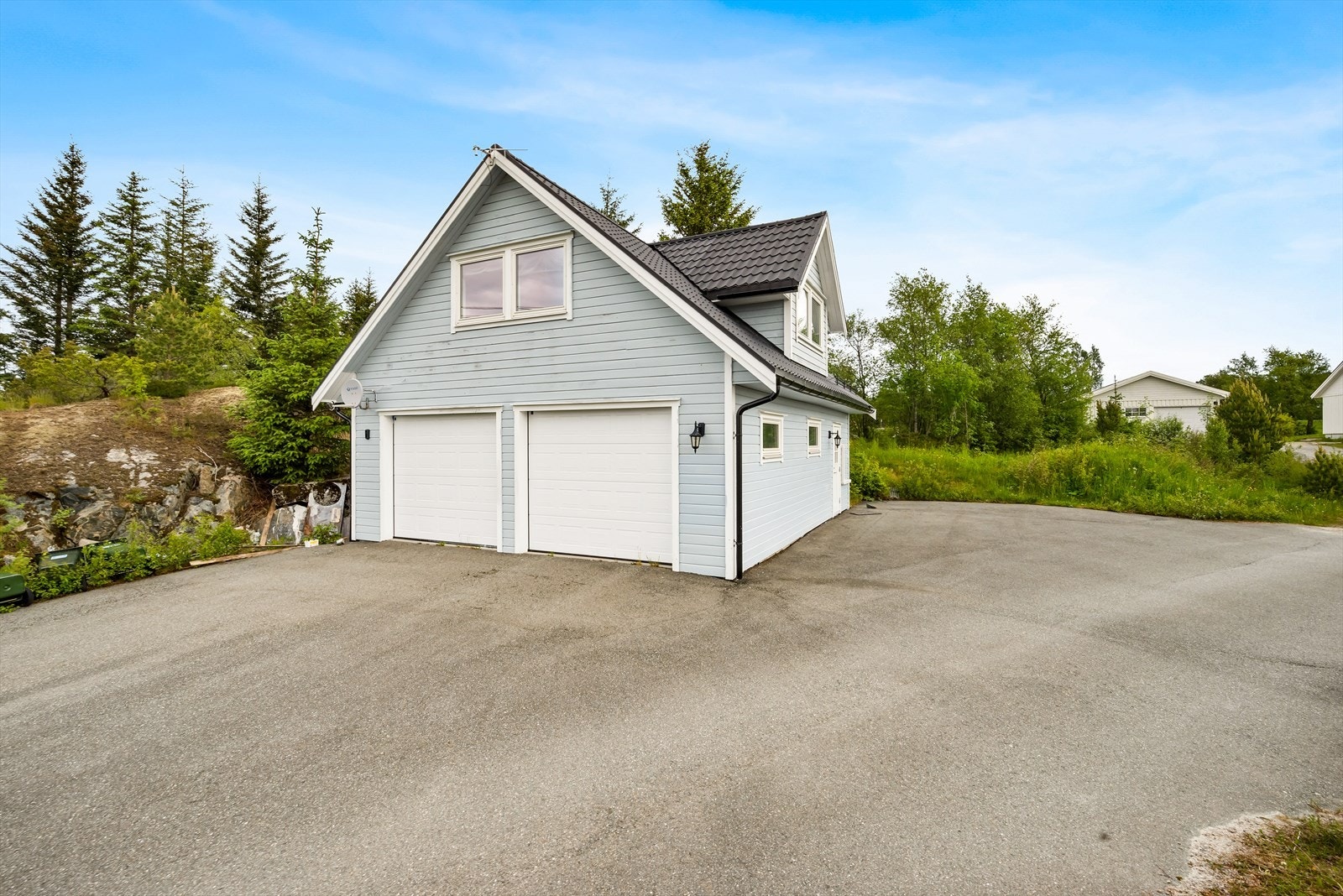 Eiendommen har en stor, asfaltert gårdsplass. I tillegg er det oppført en frittstående dobbelgarasje med egen utleiedel. Galleribilde
