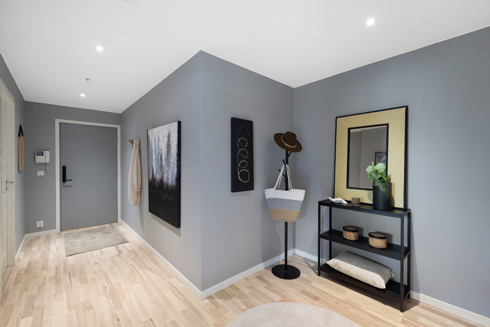 Romslig og stilfull entré med plass til oppbevaring og garderobeskap. Et praktisk og innbydende førsteinntrykk av boligen. Galleribilde