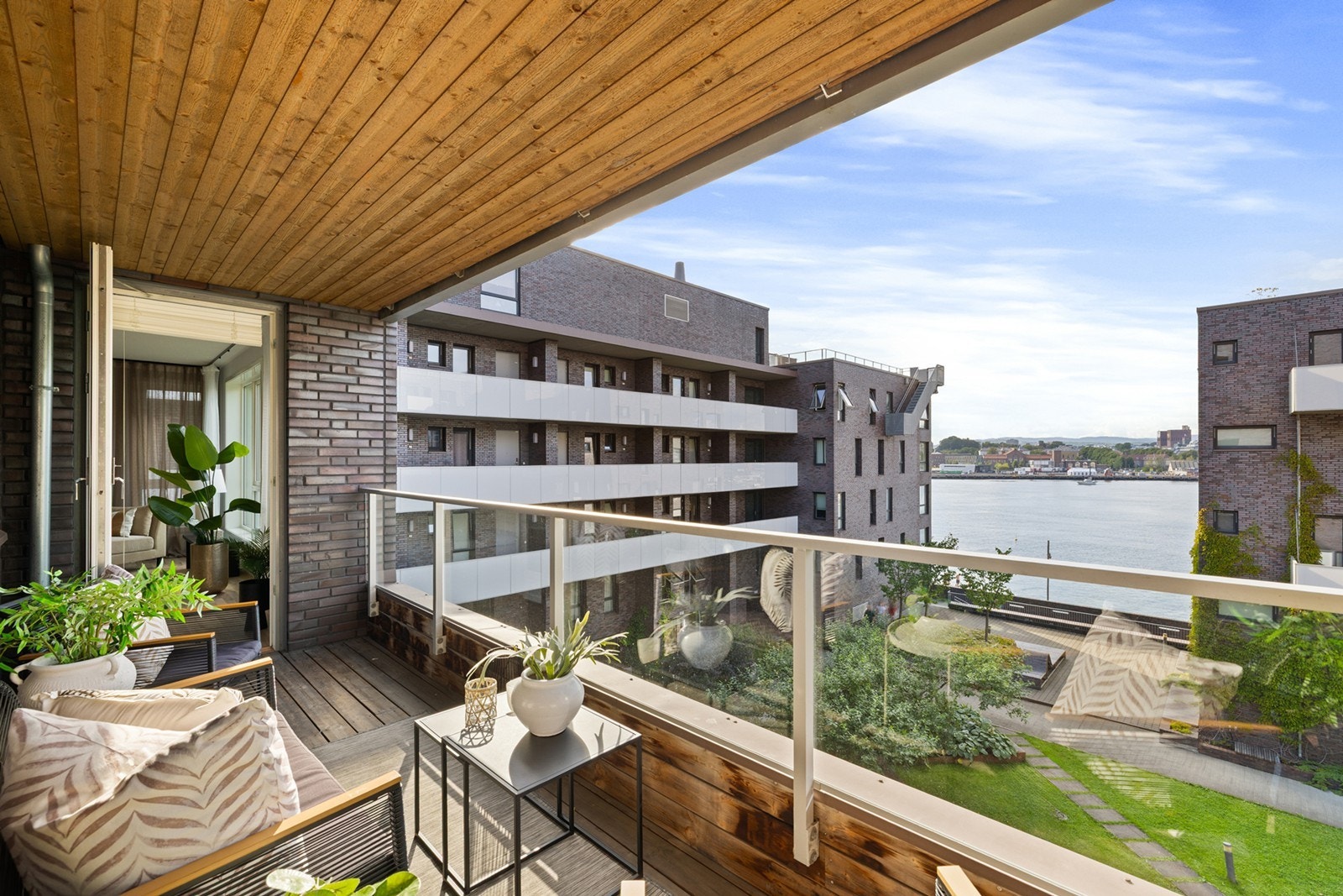 Balkongen fungerer som en lun forlengelse av stuen og byr på nydelig utsyn mot både grøntområder og fjorden. Galleribilde