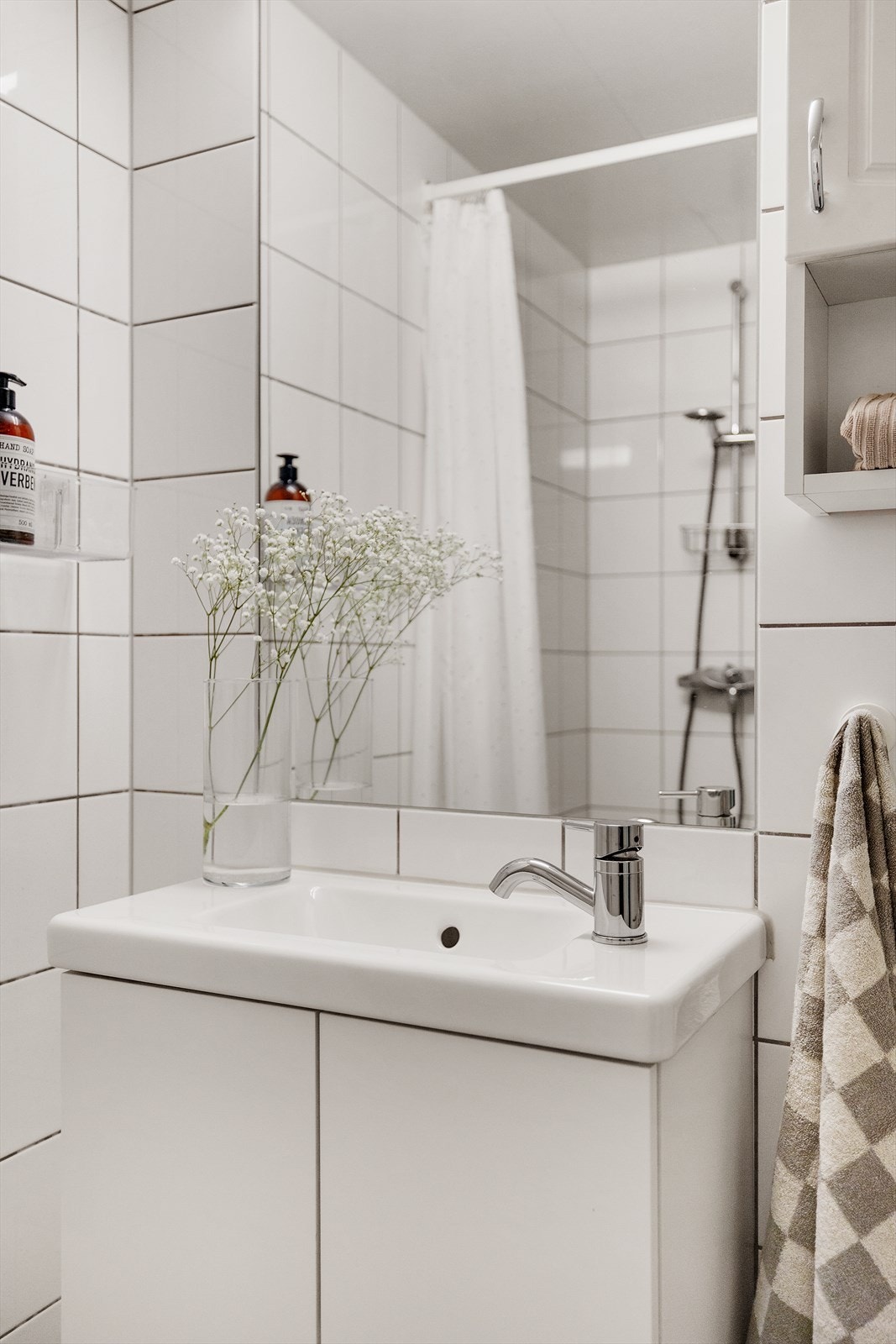 Det er innredet med dusjplass med tilhørende garnityr, servant med underskap, speil med lys over samt overskap for ekstra oppbevaring. Videre er det veggmontert wc, noe som gir en ryddig og lettstelt løsning. Galleribilde