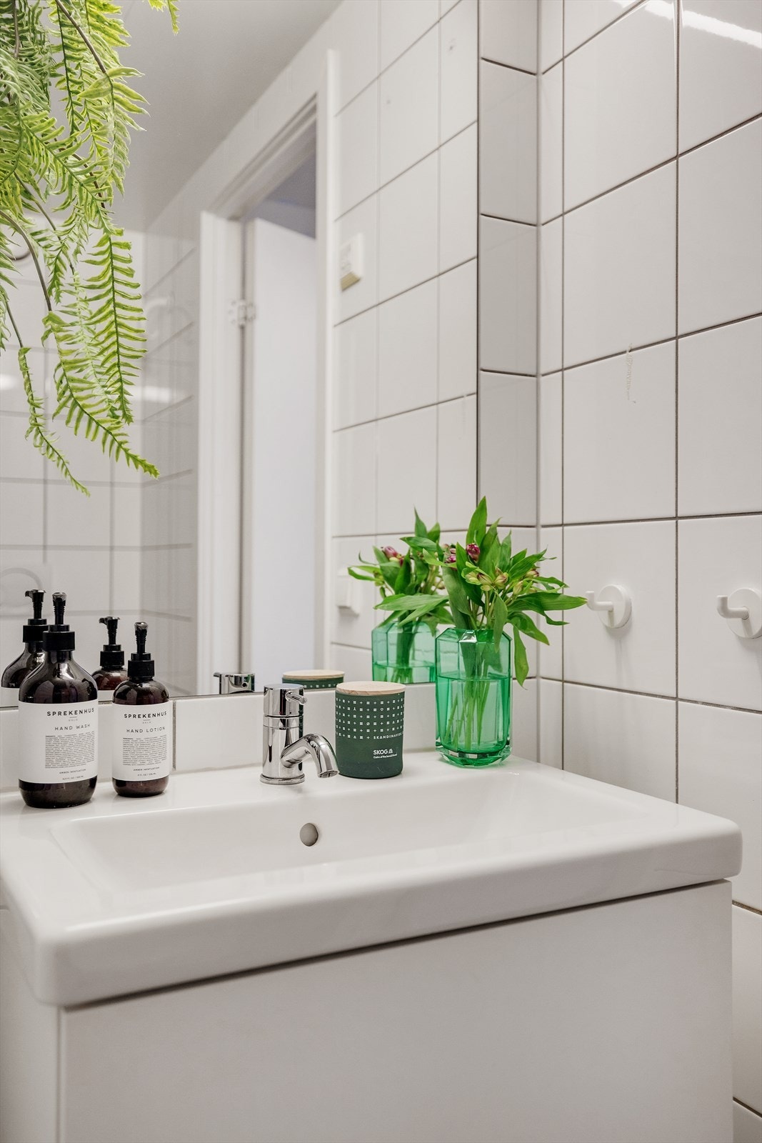 Innredningen består av veggmonterte dusjdører, servant med underskap, speil med belysning over, opplegg for vaskemaskin og veggmontert toalett. Galleribilde