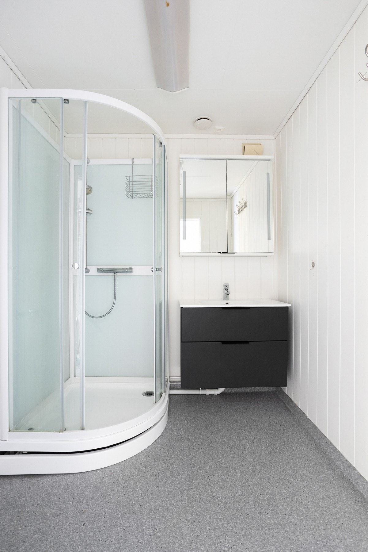 Baderom med dusj og servant med innredning. Opplegg for vaskemaskin. Galleribilde