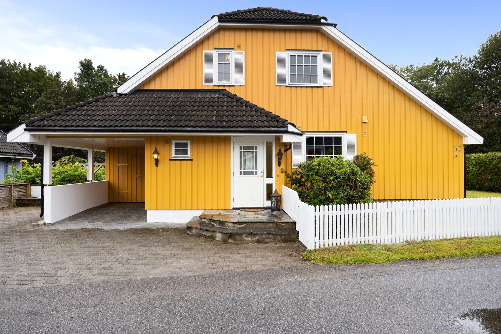 Delvis overbygget inngangsparti og port inn til inngjerdet hage. Galleribilde