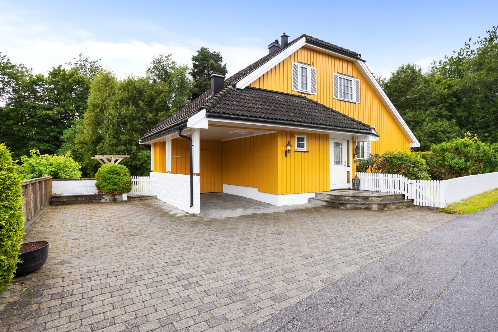 Romslig, steinlagt gårdsplass med carport/bod og mulighet for parkering. Galleribilde