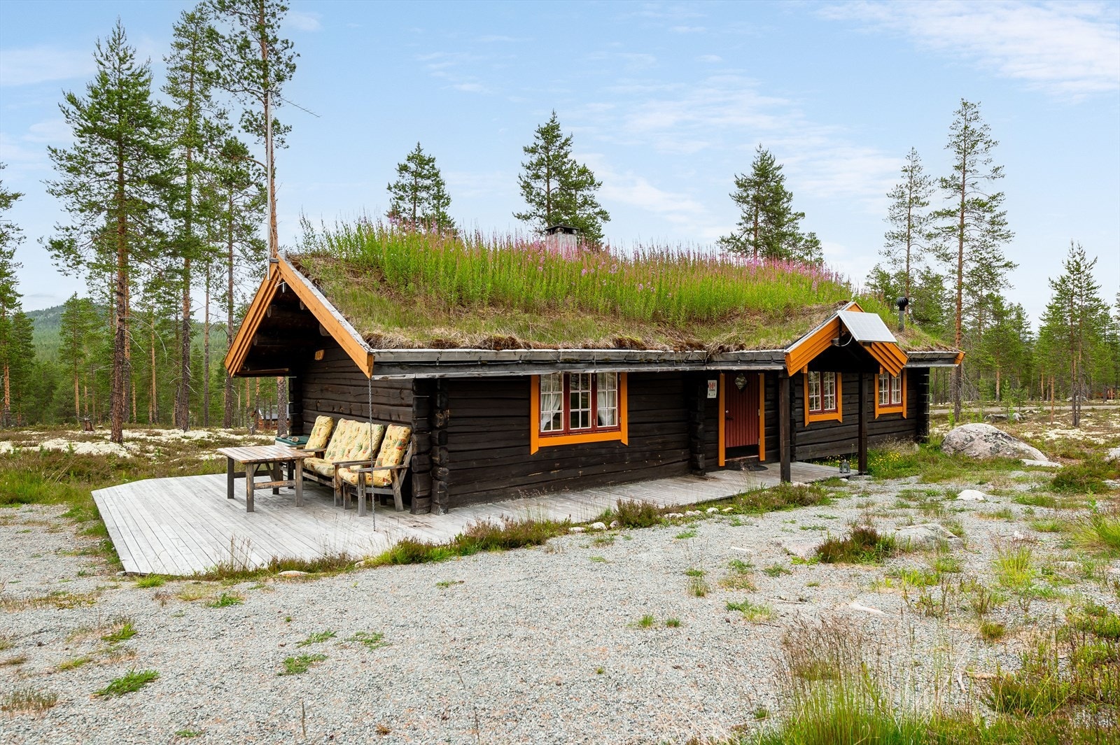 En hyggelig tømmerhytte fra 2008 med yttervegger av håndlaftet laftetømmer og tak tekket med torv. Galleribilde