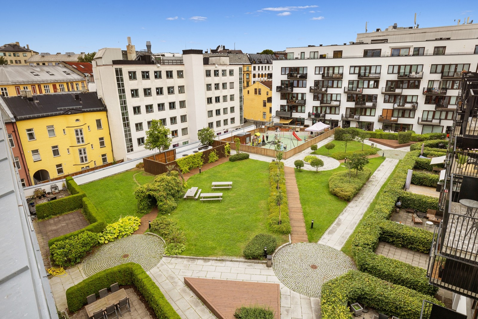 Frodig og idyllisk bakhage med sittegrupper, internveier og beplantning - kun for beboerne. Galleribilde