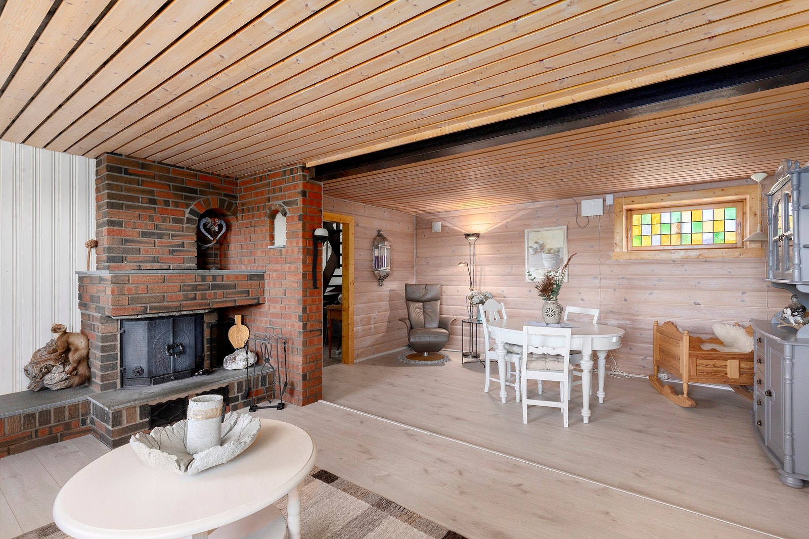 Kjellerstue på 57 kvm med peisinnsats. Sett opp mot byggemeldte tegninger er rommene "disponibelt" og "hobbyrom" sammenslått til dagens kjellerstue. Galleribilde