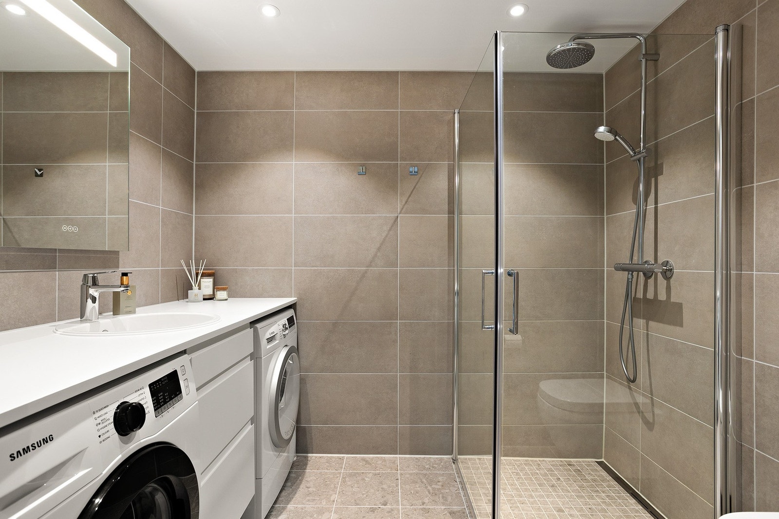 Baderommet utstråler en moderne og elegant atmosfære, med gulvvarme og flislagte vegger som skaper en frisk følelse. Galleribilde