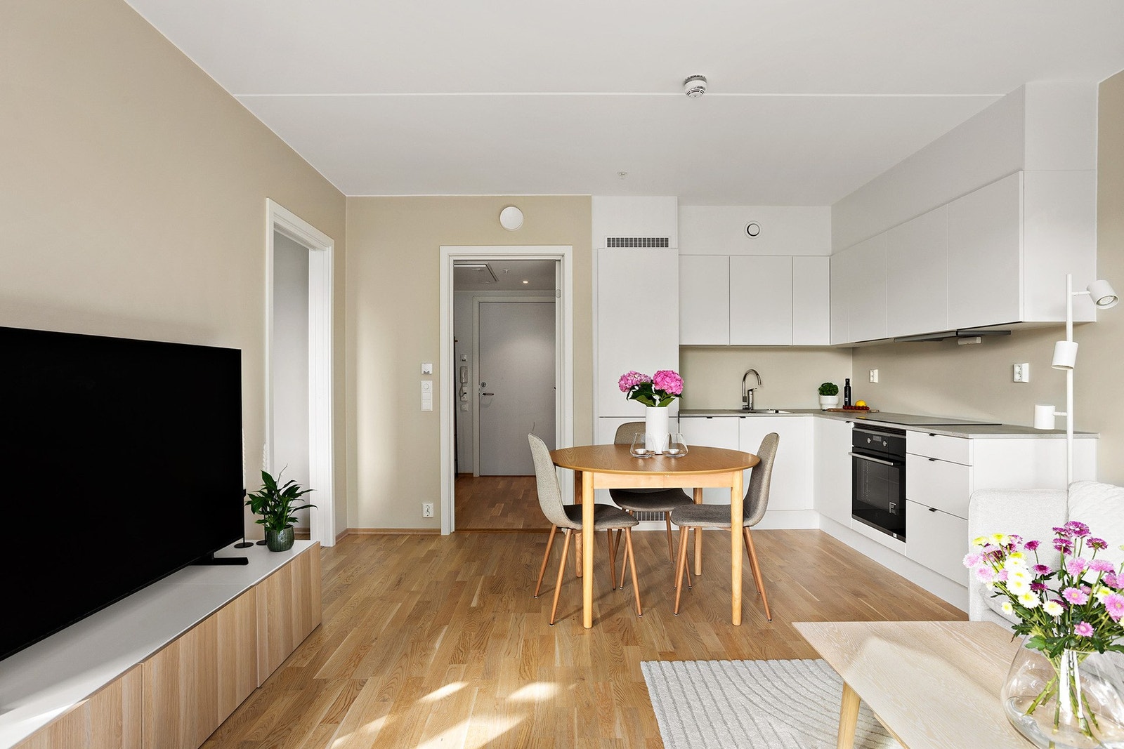 Flott kjøkkeninnredning fra HTH med elegante, lyse fronter og benkeplate av laminat med nedfelt oppvaskkum og induksjonstopp. Galleribilde