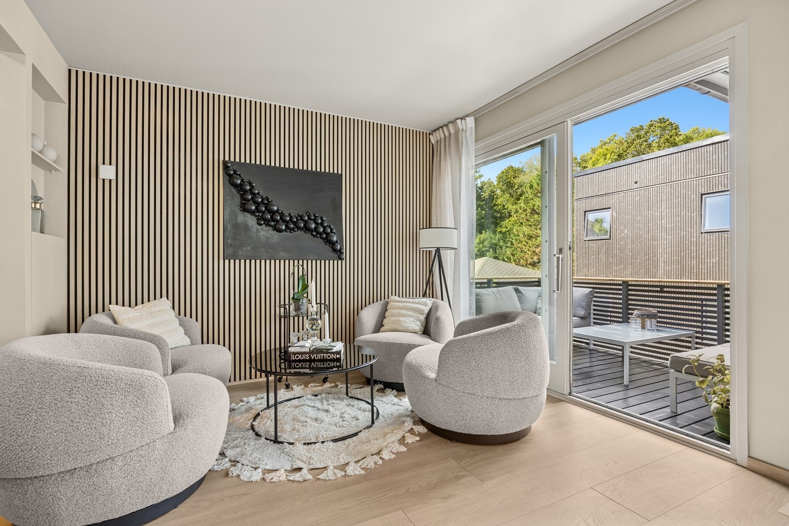 Fra den hyggelige sittegruppen med den moderne spileveggen, er det utgang til en hyggelig veranda. Galleribilde