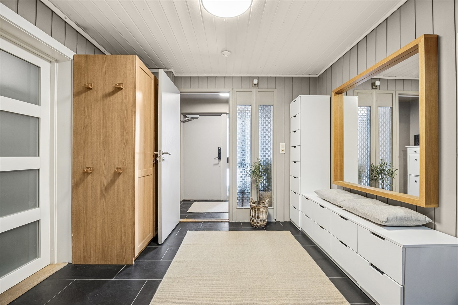Velkomsthall i 1.etg med inngang til garasje og trappeoppgang til 2.etg. Det er godt med oppbevaringsplass til sko og yttertøy i hallen. Galleribilde