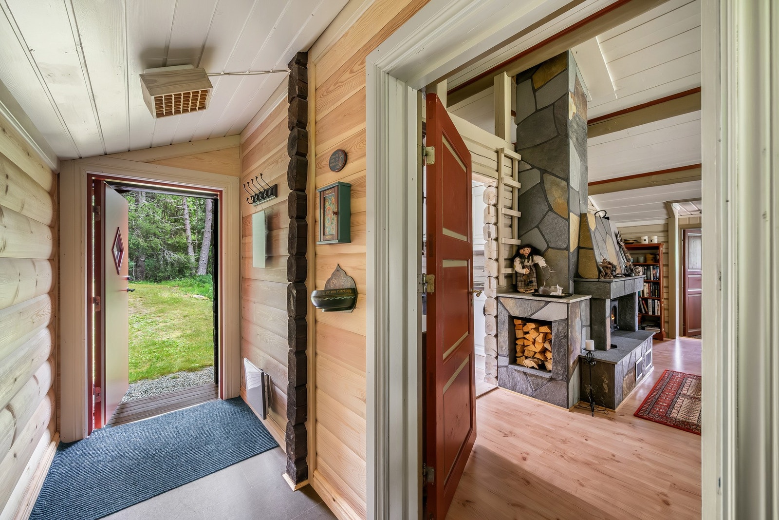 Velkommen inn, lun entré som leder videre til stue med peis og varme naturmaterialer. Galleribilde