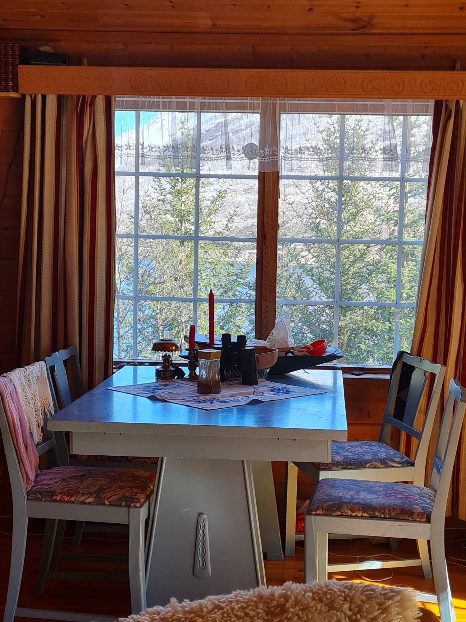 Velkommen inn i stua. Her har du en vakker fjordutsikt gjennom skogen Galleribilde