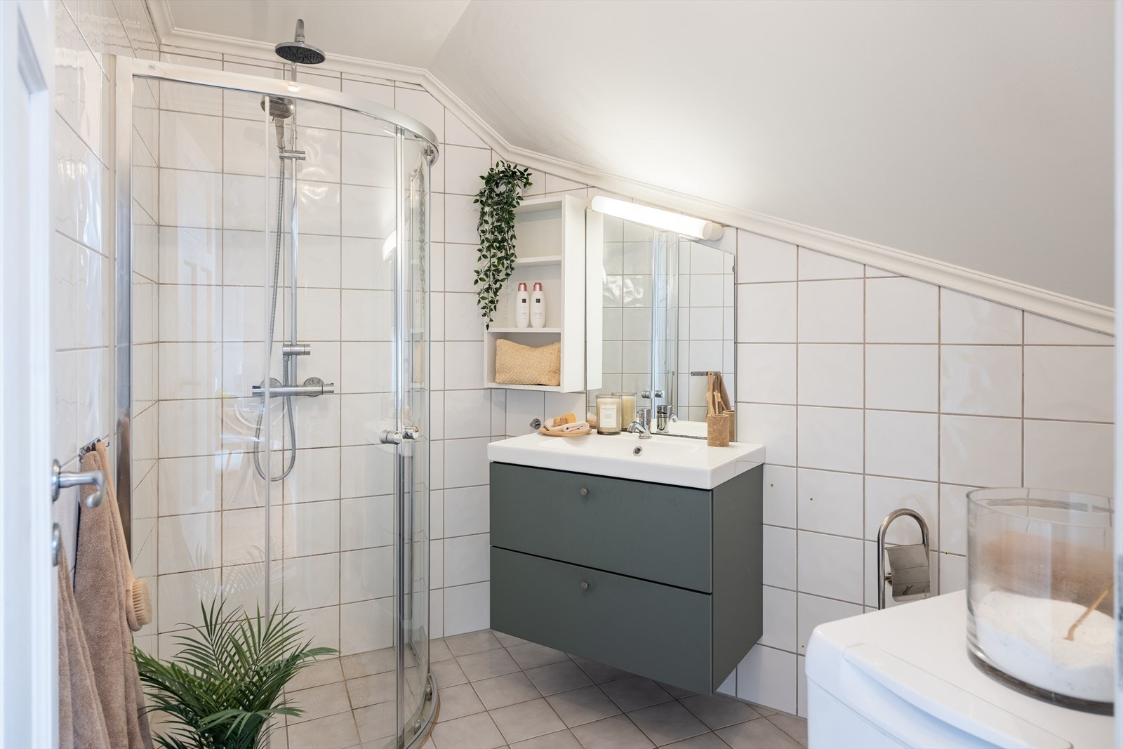 Flislagt og romslig bad på 5m² med servant og servantskap fra 2021. Galleribilde