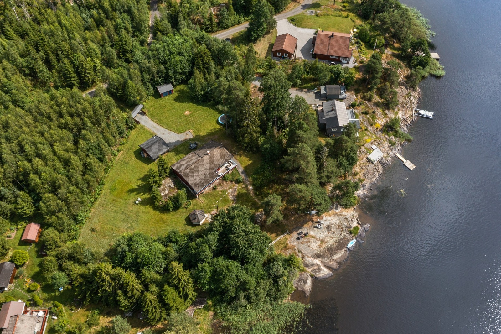 På denne solfylte tomten får du kystidyll i tråd med naturskjønt skogsterreng Galleribilde