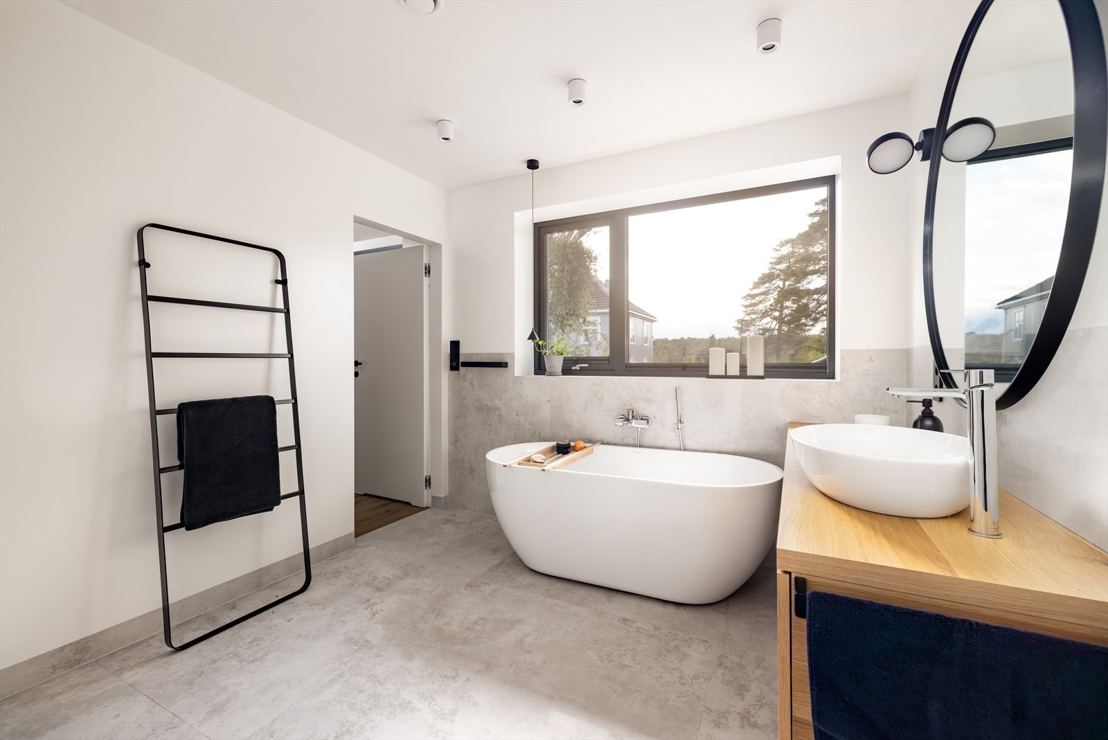 Badet fra 2023 med gulvvarme gir en deilig spafølelse på eget baderom. Her er det møblement i heltre med overliggende rund servant og rundt speil med sidelys. Galleribilde