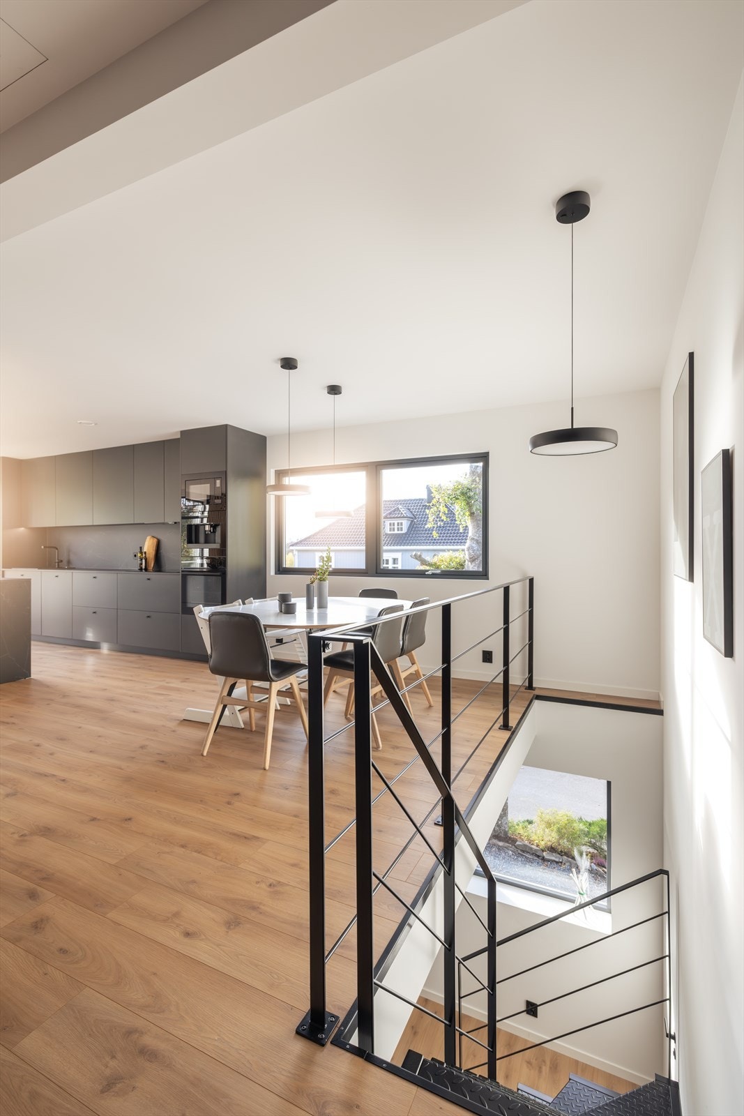 Via den stilige ståltrappen med sort rekkverk kommer man opp i boligens hovedetasje. Galleribilde