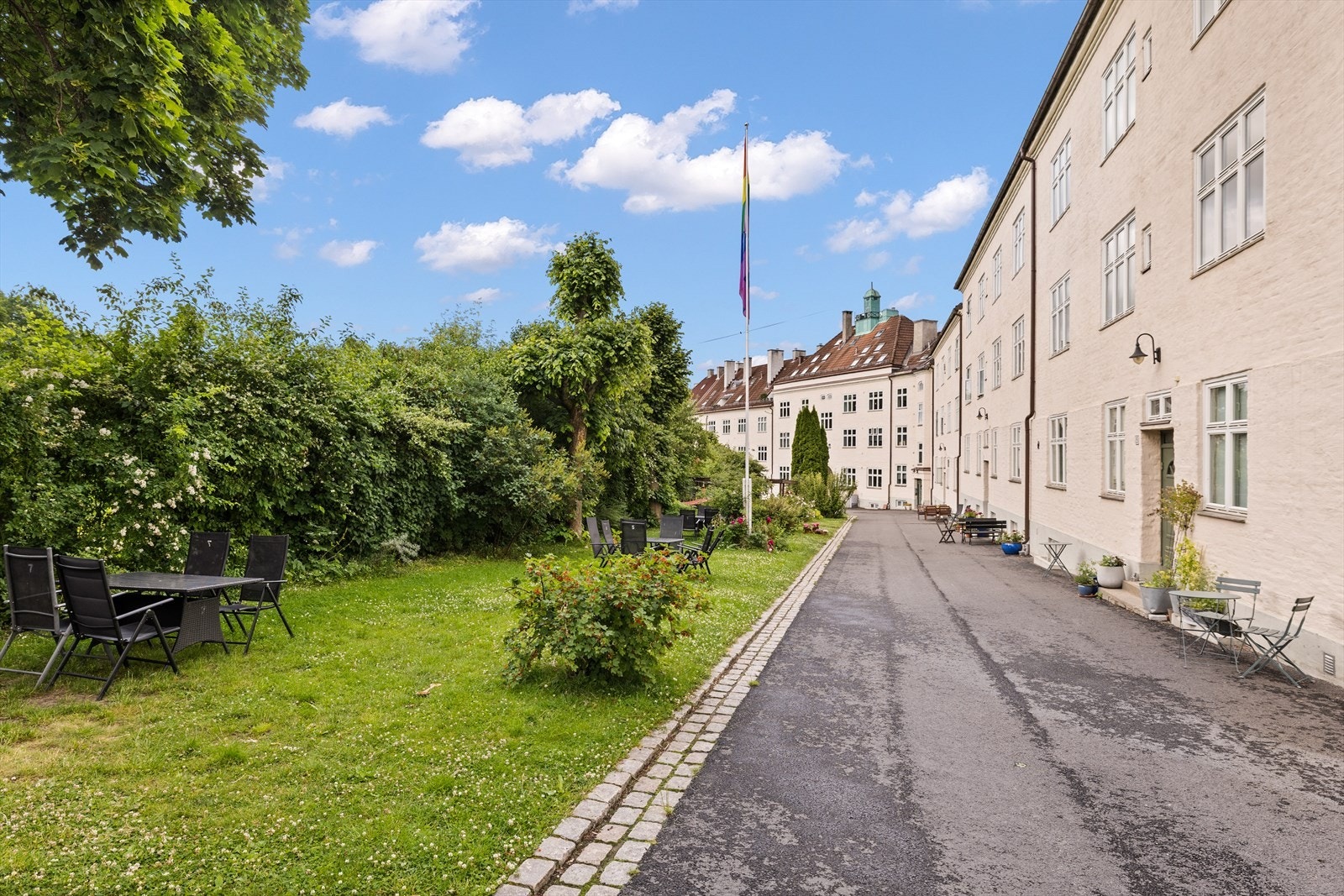 Stille og rolige omgivelser med asfaltert vei, brostein og grønne områder Galleribilde
