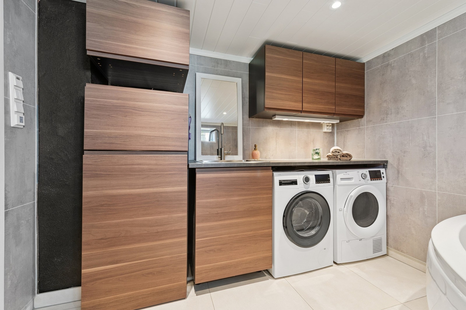 Praktisk vaskeromsdel med god skapplass og opplegg for vaskemaskin. Galleribilde