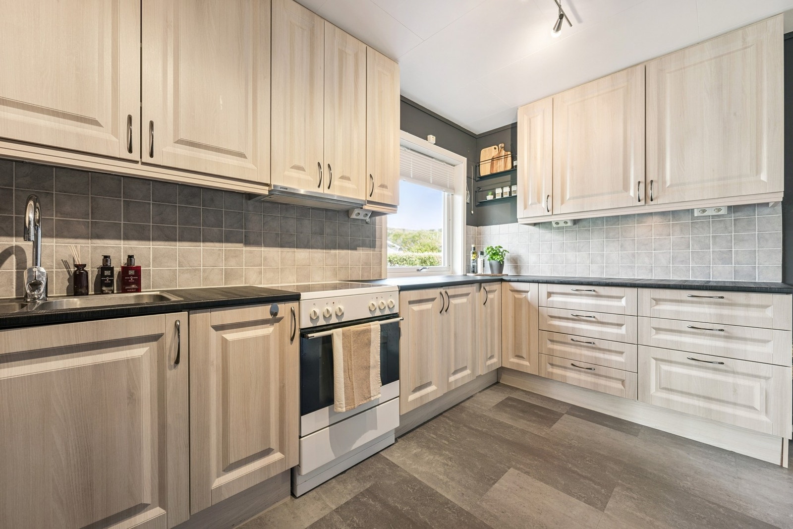 Lyst og innbydende kjøkken med rikelig skapplass og god benkeflate Galleribilde