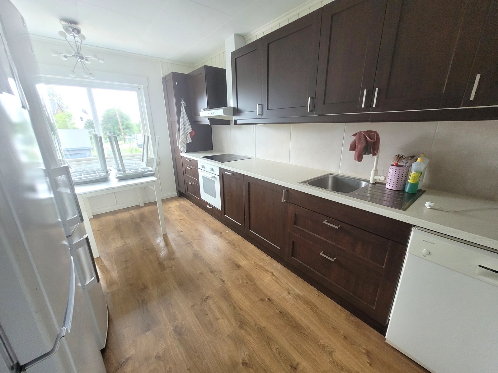 Kjøkken med hvitevarer og spiseplass. Galleribilde