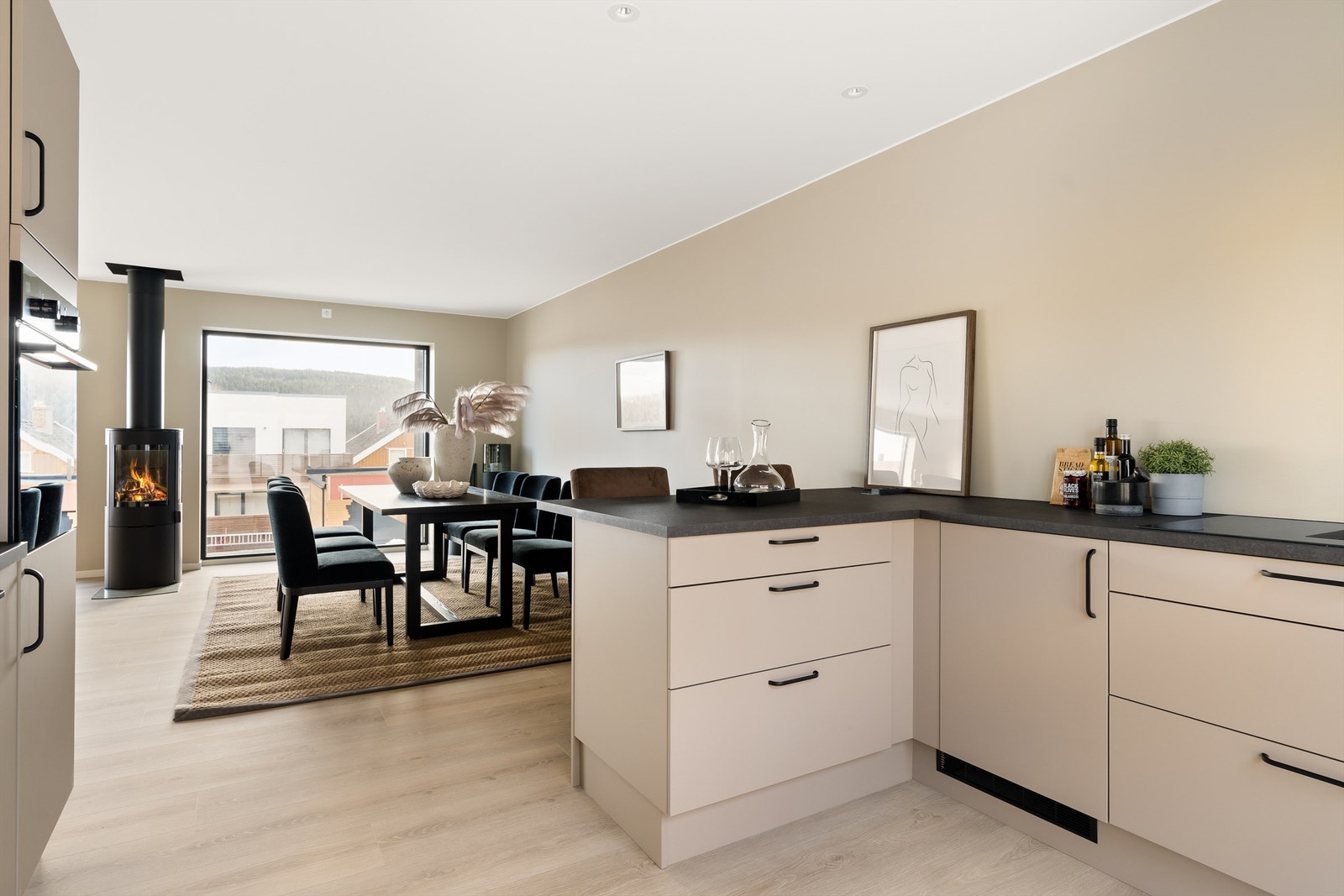 Kjøkkenet har en praktisk barløsning med sitteplasser. Fra kjøkkenet har man utgang til hage. Galleribilde