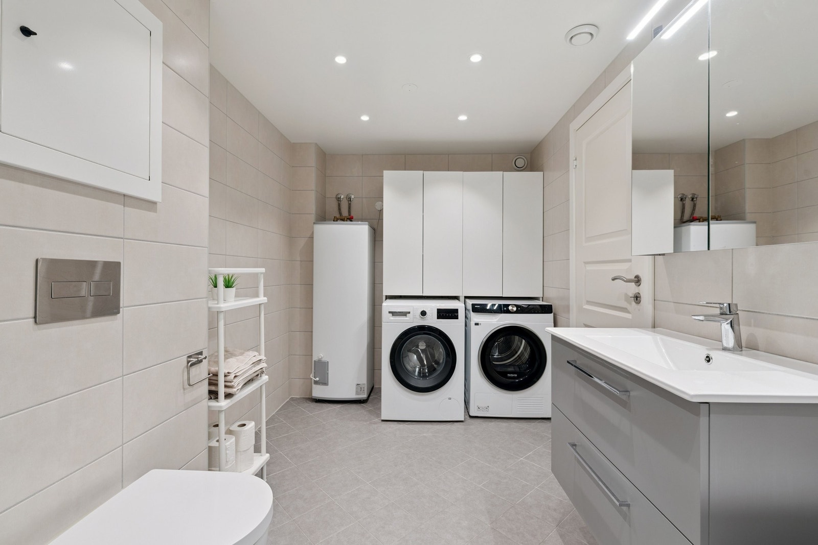 God plass til vaskemaskin og tørketrommel på dette meget romslige badet. Galleribilde