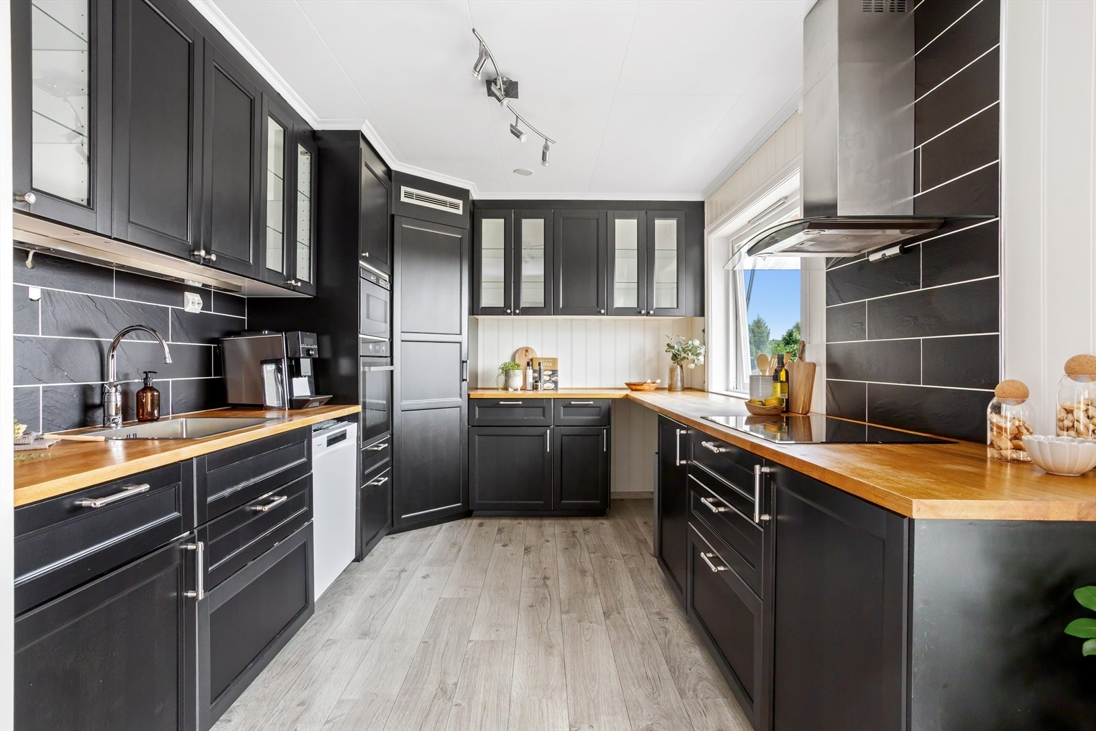 Kjøkkenet har innredning med profilerte fronter. Benkeplaten er avheltre. Det er kjøleskap, oppvaskmaskin, induksjonstopp, micro,
stekeovn og komfyrvakt. Kjøkkenventilator med avtrekk ut. Galleribilde