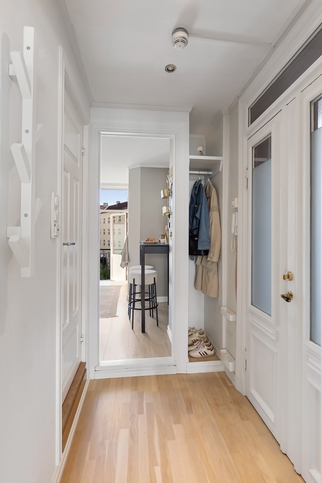Hyggelig, lys entré med garderobenisje og pene, originale fløydører inn til leiligheten. Galleribilde