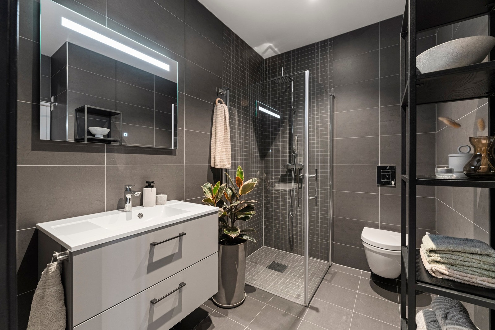 Badet fremstår moderne og lekkert, varmekabler i gulv, innfelte downlights og balansert ventilasjon som sørger for både komfort og funksjonalitet Galleribilde