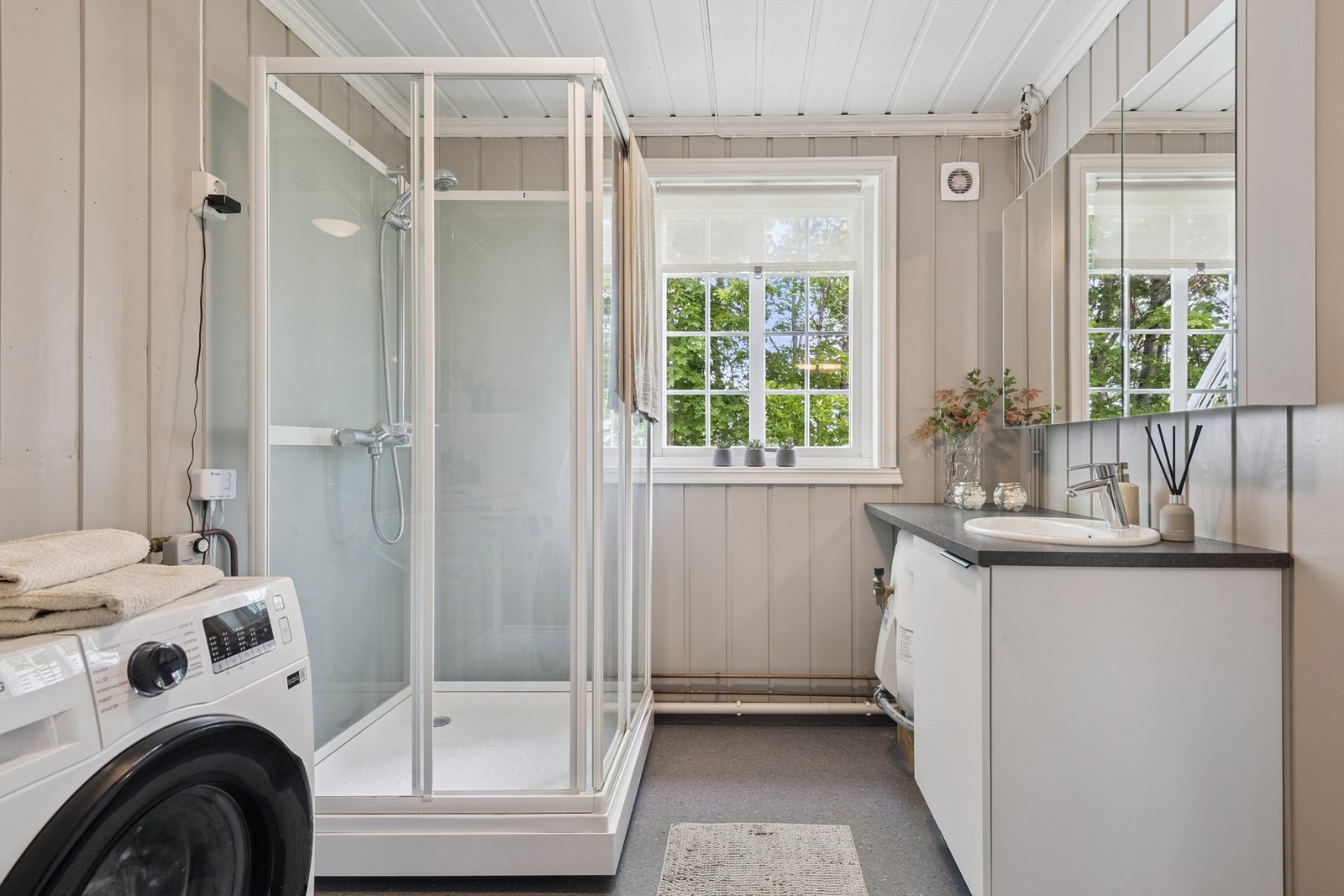 Romslig bad med dusjkabinett og opplegg for vaskemaskin. Galleribilde