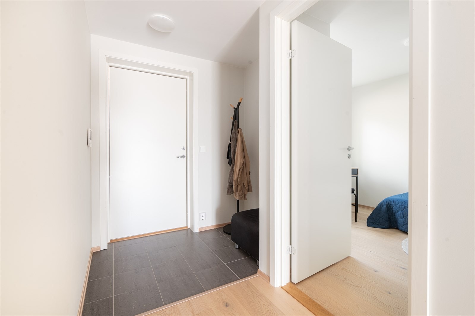 Med adkomst fra svalgangen kommer man inn i gangen, hvor det er flislagt gulv og lysmalte veggoverflater. Her er en liten nisje med plass til sko- og ytterklær, hvor man eventuelt kan sette inn skyvedørsgarderobe om ønskelig. Det er ikke varme i gulvet. Galleribilde