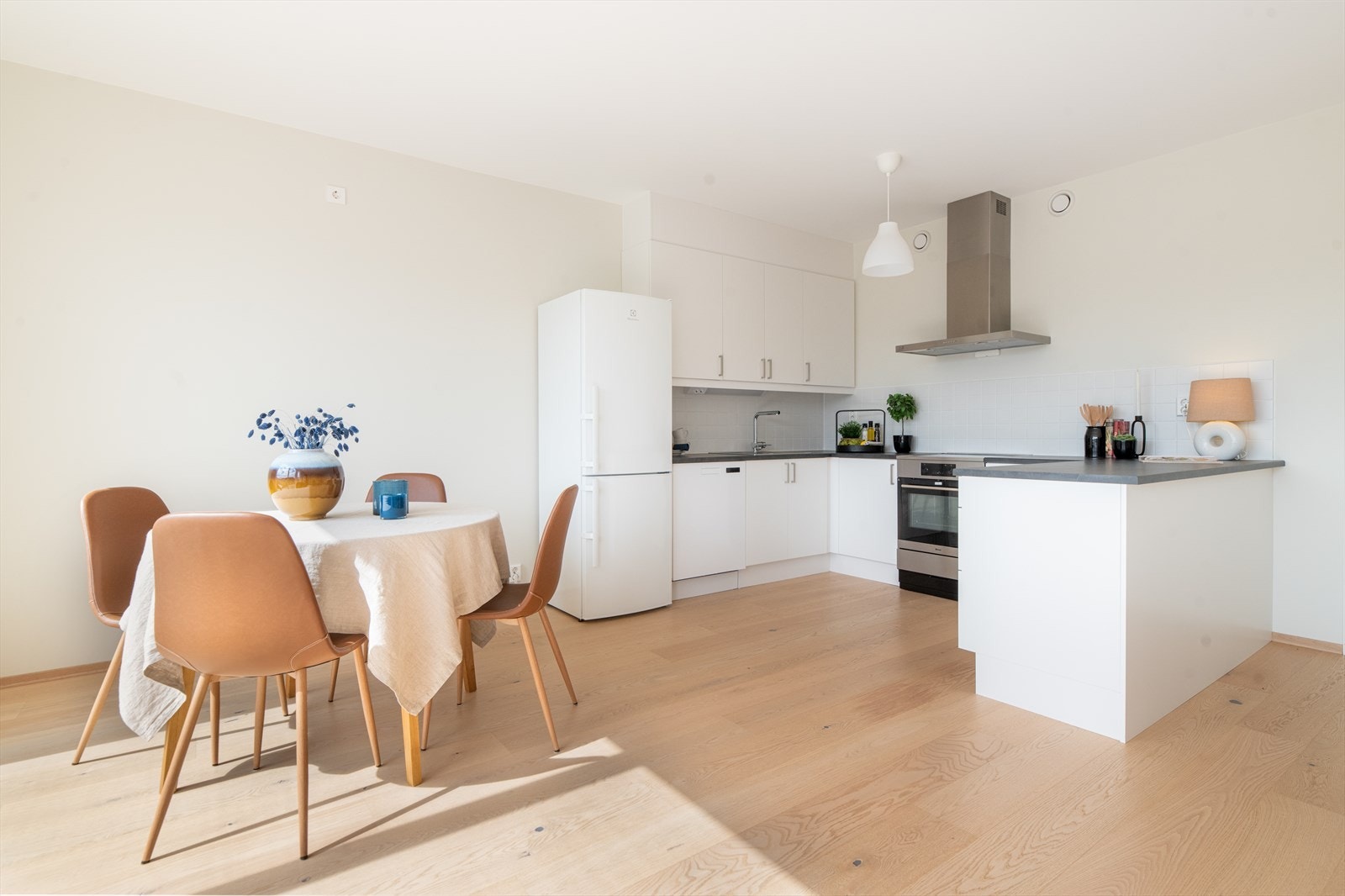 Stua og kjøkkenet har en sosial og åpen løsning, hvor store sydvendte vindusflater tilfører rikelig med dagslys. Galleribilde