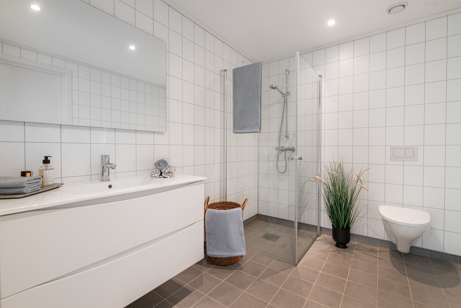 I dusjhjørnet er det plassbesparende, innfellbare glassvegger, og badet har veggmontert toalett. Down-light belysning i tak. Galleribilde